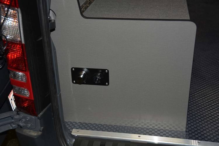 Interior view of compartment doors open exposing the toilet in a  Sportsmobile conversion van