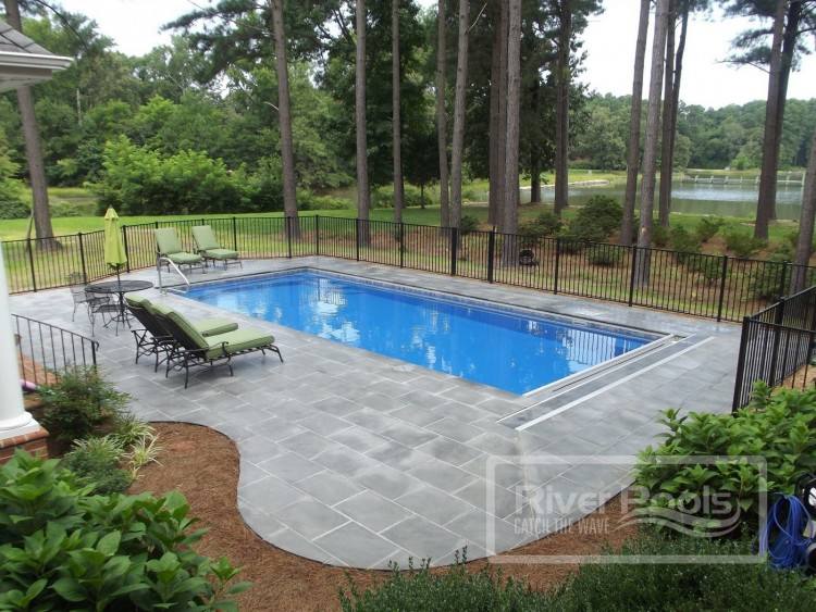 Traditional rectangular pool with water features shooting into the pool and  an automatic cover