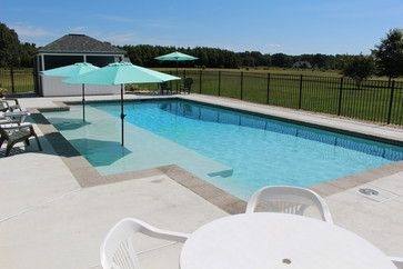 Bay Front rectangle pool with a negative edge, rim overflow, dark plaster,  inset spa, and large sun deck